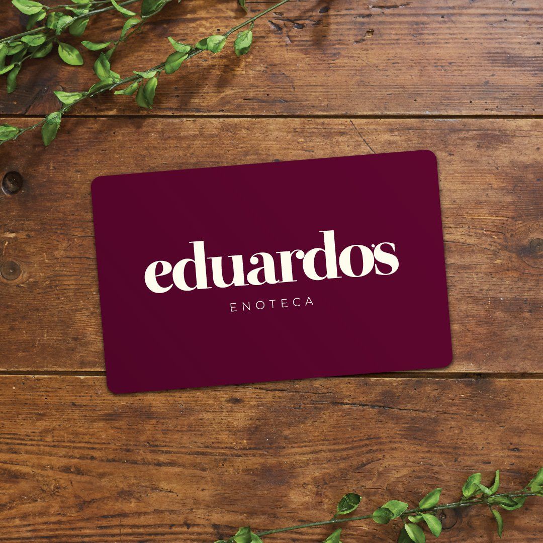 Eduardo's Enoteca burgundy gift card on a wooden table with green leaves
